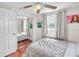Bright bedroom with hardwood floors, large mirrored closet, and a ceiling fan at 5543 Moog Rd, New Port Richey, FL 34652