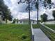 Spacious backyard with direct access to a lake, featuring a private walkway and lush greenery at 5555 Baffin Cir, Spring Hill, FL 34606