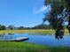 Picturesque view of the pond with the dock on a bright sunny day with clear blue skies at 5555 Baffin Cir, Spring Hill, FL 34606