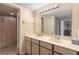 Bright bathroom features double sink vanity and shower with patterned curtain at 6035 Sea Ranch Dr # 410, Hudson, FL 34667
