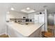 Well-maintained kitchen featuring white appliances, plenty of counter space, and a breakfast bar at 6035 Sea Ranch Dr # 410, Hudson, FL 34667