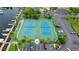 Aerial view of community tennis courts, surrounded by lush landscaping and parking at 6035 Sea Ranch Dr # 410, Hudson, FL 34667