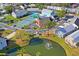 Aerial view showcasing community amenities: tennis courts, a pond with fountain, and inviting recreational facilities at 6702 Dartmoor Ln # 7A, New Port Richey, FL 34653