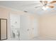 This bedroom includes ensuite bathroom access, a ceiling fan, and neutral-toned walls at 6702 Dartmoor Ln # 7A, New Port Richey, FL 34653