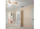 This bedroom includes ensuite bathroom access, and neutral-toned walls. A ceiling fan helps keep you cool at 6702 Dartmoor Ln # 7A, New Port Richey, FL 34653