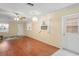 Bright living room with hardwood floors, a ceiling fan and large windows bringing in lots of natural light at 6702 Dartmoor Ln # 7A, New Port Richey, FL 34653
