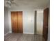 Bedroom with wood flooring, large closet, and view to an adjacent room at 7338 Foxbloom Dr, Port Richey, FL 34668