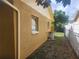 Exterior view of the yellow house with a chain link fence surrounding the yard at 7338 Foxbloom Dr, Port Richey, FL 34668