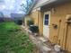 Backyard exterior of a yellow house with an AC unit and a gated fence for privacy at 7338 Foxbloom Dr, Port Richey, FL 34668