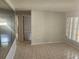 Neutral living room with tile floors with an adjacent hallway and visible bedroom doorway at 7338 Foxbloom Dr, Port Richey, FL 34668