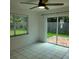 Cozy bedroom featuring a window, tile flooring, and sliding doors at 8504 Lafitte Dr, Hudson, FL 34667