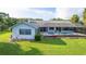 Home's backyard featuring a screened pool, manicured landscaping, and well-maintained green lawn at 8522 Cranes Roost Dr, New Port Richey, FL 34654