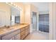 Bathroom featuring double sinks, vanity, and a glass-enclosed shower at 8522 Cranes Roost Dr, New Port Richey, FL 34654