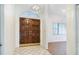 Grand foyer featuring tile floors, double wooden doors and decorative light fixture at 8522 Cranes Roost Dr, New Port Richey, FL 34654