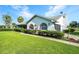 Charming home exterior featuring lush green lawn, tasteful shrubbery, and arched windows at 8522 Cranes Roost Dr, New Port Richey, FL 34654