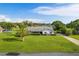 Well-kept single-story house featuring an expansive front lawn and a mature palm tree at 8522 Cranes Roost Dr, New Port Richey, FL 34654