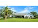 Charming single-story home with a lush green lawn, mature palm tree, and well-maintained landscaping at 8522 Cranes Roost Dr, New Port Richey, FL 34654