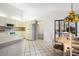 Bright eat-in kitchen with white appliances, tile floors, and a decorative overhead light at 8522 Cranes Roost Dr, New Port Richey, FL 34654