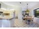 Bright kitchen with white appliances, tile floors, and a decorative overhead light over a dining area at 8522 Cranes Roost Dr, New Port Richey, FL 34654