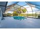 Screened-in pool and deck area with a view of the lake and surrounding greenery at 8522 Cranes Roost Dr, New Port Richey, FL 34654