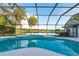 Screened-in pool and deck area with a view of the lake and surrounding greenery at 8522 Cranes Roost Dr, New Port Richey, FL 34654