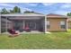 Large backyard featuring a screened patio, fire pit, and well-maintained lawn, perfect for outdoor entertaining and relaxation at 9309 Edistro Pl, New Port Richey, FL 34654