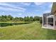 Expansive backyard view with a pond, lush greenery, and a screened patio, offering a serene and private outdoor space at 9309 Edistro Pl, New Port Richey, FL 34654