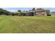 Spacious backyard featuring a screened patio, fire pit, and ample lawn space, creating an ideal setting for outdoor activities at 9309 Edistro Pl, New Port Richey, FL 34654