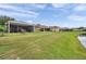 Extensive lawn area with a screened patio, fire pit, and lush greenery providing a tranquil outdoor retreat at 9309 Edistro Pl, New Port Richey, FL 34654