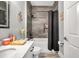 Well-lit bathroom featuring a shower-tub combo with gray tile surround and modern fixtures at 9309 Edistro Pl, New Port Richey, FL 34654