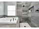Modern bathroom featuring a soaking tub and tiled walk-in shower with a built-in niche at 9309 Edistro Pl, New Port Richey, FL 34654