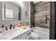 Bright bathroom featuring a sleek vanity, lighted mirror and shower/tub combo with gray tile at 9309 Edistro Pl, New Port Richey, FL 34654
