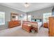 Well-lit bedroom with a dresser, chest, and neutral decor at 9309 Edistro Pl, New Port Richey, FL 34654