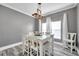 Dining room featuring a glass-top table with white chairs and stylish overhead lighting at 9309 Edistro Pl, New Port Richey, FL 34654