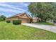 Single-Gathering home with three-car garage, verdant lawn, and neat landscaping on a sunny day at 9309 Edistro Pl, New Port Richey, FL 34654