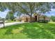 Well-maintained single-Gathering home with a spacious driveway, lush lawn, and mature trees at 9309 Edistro Pl, New Port Richey, FL 34654