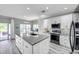 Bright kitchen with white cabinetry, center island, stainless appliances, and view to the backyard at 9309 Edistro Pl, New Port Richey, FL 34654