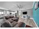 Spacious living room with modern ceiling fan, fireplace and updated kitchen view at 9309 Edistro Pl, New Port Richey, FL 34654