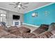 Cozy living room featuring a fireplace, TV, sectional, and blue accent wall at 9309 Edistro Pl, New Port Richey, FL 34654