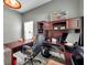 Home office with a wooden desk, ergonomic chair, and display shelves for collectables at 9309 Edistro Pl, New Port Richey, FL 34654