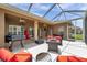 Covered outdoor patio with a grill, cozy seating, and a scenic view of the lake at 9309 Edistro Pl, New Port Richey, FL 34654