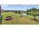 Lush backyard with fire pit and a serene pond, perfect for enjoying nature and relaxing outdoors at 9309 Edistro Pl, New Port Richey, FL 34654