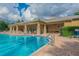 Community pool featuring lounge chairs, umbrellas, and a covered patio area at 9309 Edistro Pl, New Port Richey, FL 34654