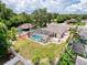 The aerial view showcases the property's backyard oasis, with a pool and meticulously landscaped areas at 9431 Spring Hill Dr, Spring Hill, FL 34608