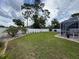 Landscaped backyard boasts screened pool and privacy fence in a partially cloudy day at 9431 Spring Hill Dr, Spring Hill, FL 34608