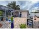 Rear view shows paver patio, seating, screen pool enclosure, grill, and home exterior at 9431 Spring Hill Dr, Spring Hill, FL 34608