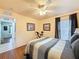 Inviting bedroom featuring hardwood floors, a ceiling fan, and a view into the hallway at 9431 Spring Hill Dr, Spring Hill, FL 34608