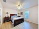 Bright bedroom with hardwood flooring, a ceiling fan, a window with blinds, and two nightstands with lamps at 9431 Spring Hill Dr, Spring Hill, FL 34608