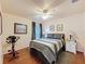Comfortable bedroom featuring hardwood floors, a ceiling fan, and ample natural light from the windows at 9431 Spring Hill Dr, Spring Hill, FL 34608