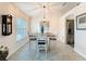 This dining room features wood dining table, white chairs, beige walls, a chandelier and tile flooring at 9431 Spring Hill Dr, Spring Hill, FL 34608